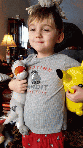 a young boy wearing a grey shirt that says bedtime on it