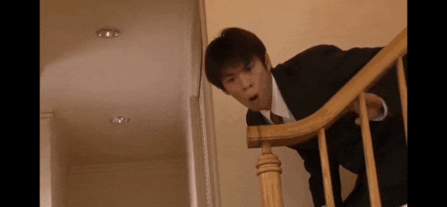 a man in a suit and tie is standing on top of a set of stairs .