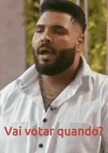 a man with a beard is wearing a white shirt and says " vai votar quando "