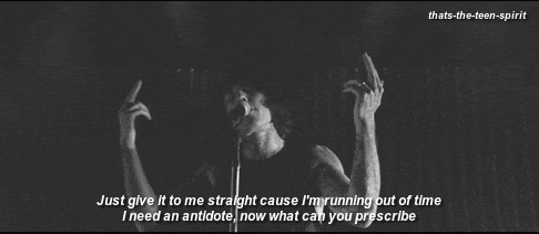 a man singing into a microphone with the words just give it to me straight