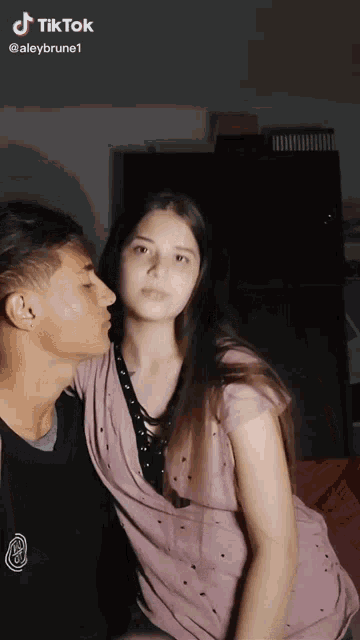 a man kissing a woman on the cheek with a tiktok watermark on the bottom