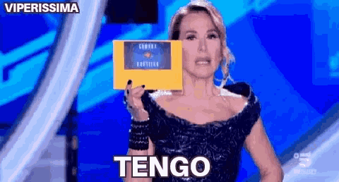a woman in a black dress is holding a sign that says " tengo "