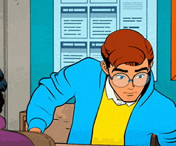 a man in a blue jacket and yellow sweater is sitting at a desk