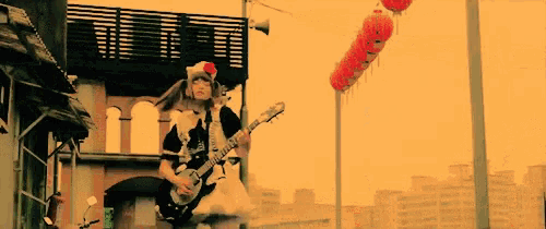 a girl in a maid outfit plays a guitar