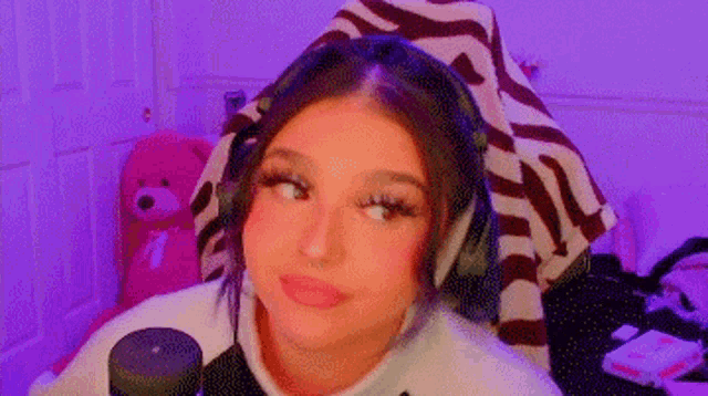 a woman wearing headphones is sitting in a chair in front of a microphone .