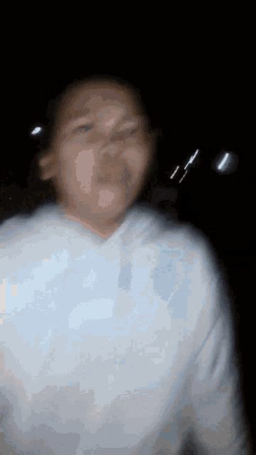 a blurry picture of a person wearing a white hoodie with the letter s on it