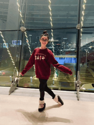 a young girl wearing a red sweater that says new york city on it