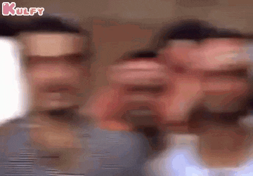 a blurry picture of three men standing next to each other with their faces visible .