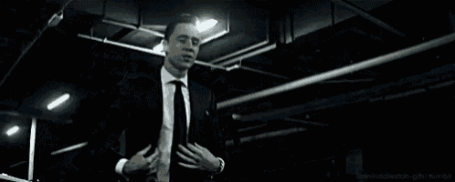 a man in a suit and tie is standing next to a pillar with the number n9 on it .