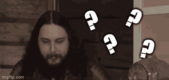 a man with long hair and a beard is surrounded by question marks ..