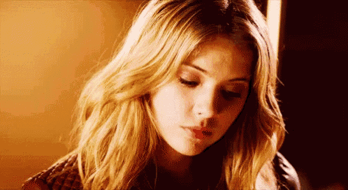 a close up of a woman 's face with long blonde hair and a nose ring .