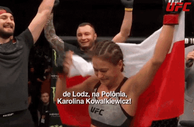 a woman in a ufc shirt holds a polish flag over her head