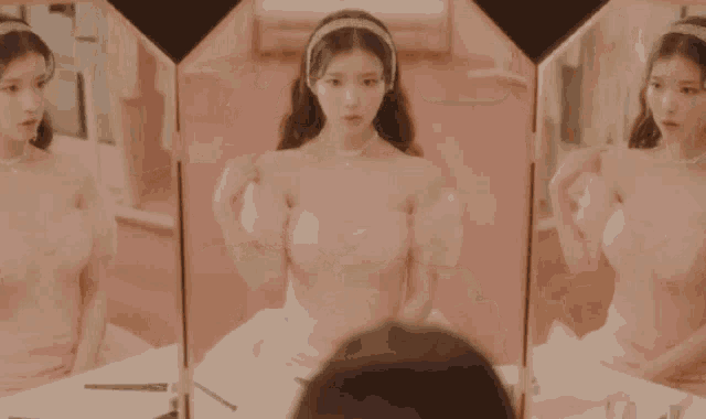 a woman in a pink dress is sitting in front of a mirror