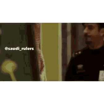 a man in a black shirt is standing next to another man in a black shirt in a room .
