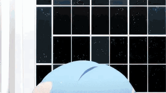a person in a blue shirt is standing in front of a window .