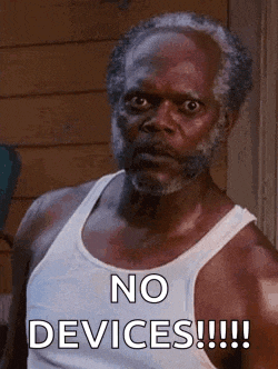 a man with a beard is wearing a white tank top and says `` no devices !!! ''