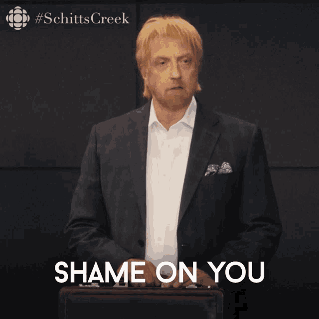 a man in a suit is holding a briefcase with the words shame on you below him