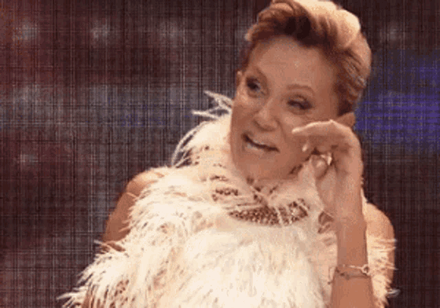 a woman is wearing a fur coat and a feather boa .
