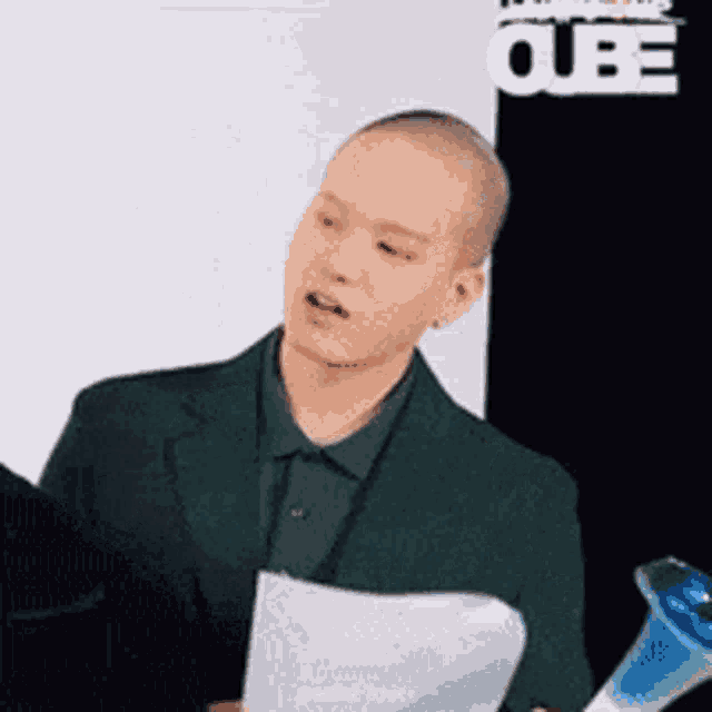 a man in a green suit is holding a piece of paper