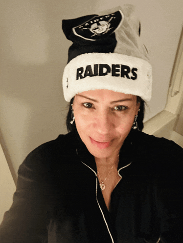 a woman wearing a hat that says raiders