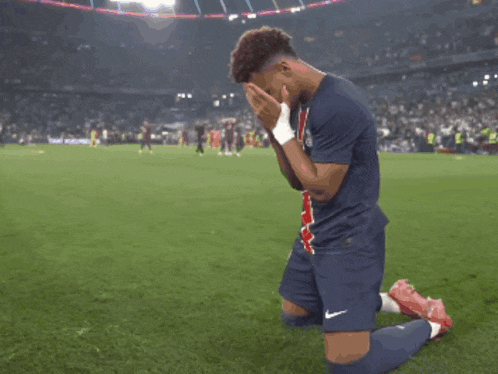 a soccer player is kneeling down with his hands on his face