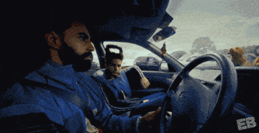 a man in a blue jacket is driving a car with a dog in the back seat