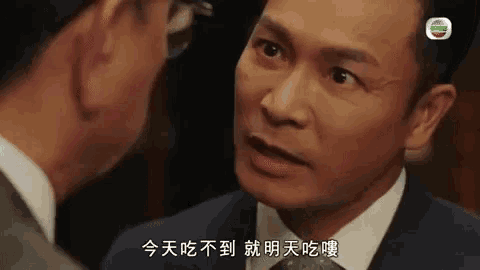 a man in a suit and tie is talking to another man in chinese .