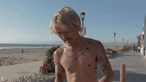 a man without a shirt has a tattoo on his chest that says " i 'm tired "