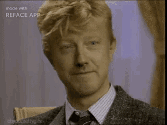 a man in a suit and tie is smiling with the reface app visible in the corner