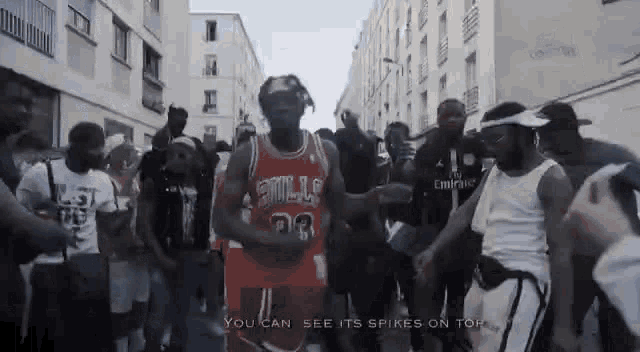 a man wearing a bulls jersey is dancing in front of a crowd of people .