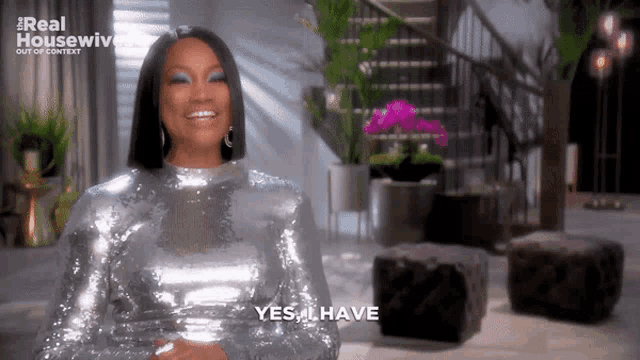 a woman in a silver sequined dress is smiling and saying yes i have