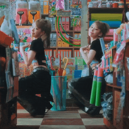 two women kneeling in front of a candy machine that says candy