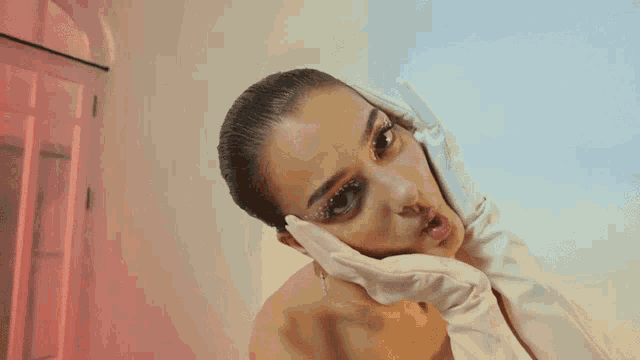 a woman with white gloves on her face