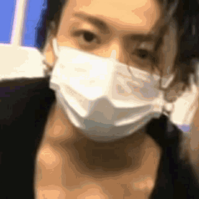 a woman wearing a face mask is looking at the camera .