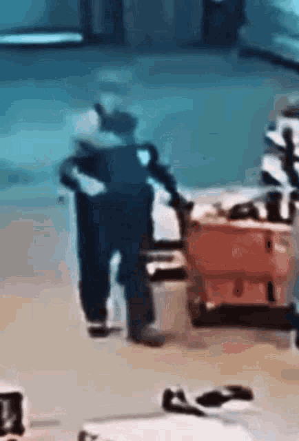 a man is pushing a cart with a suitcase in it .