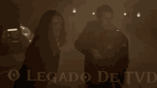 a man and a woman are standing next to each other with o legado de tvd written on the bottom right