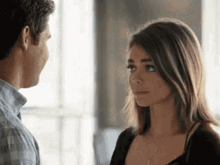 a man and a woman are looking at each other and making a face .