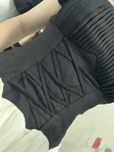 a person is holding a black item with a lace back