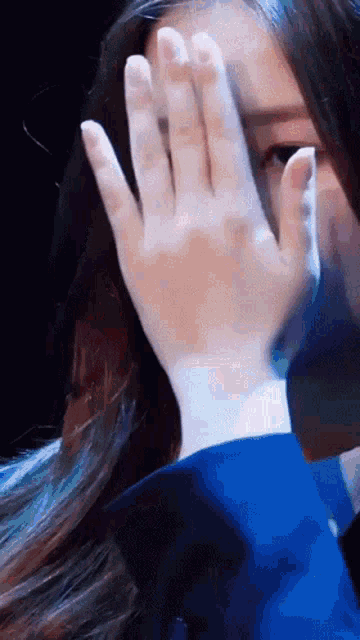 a close up of a woman covering her face with her hands
