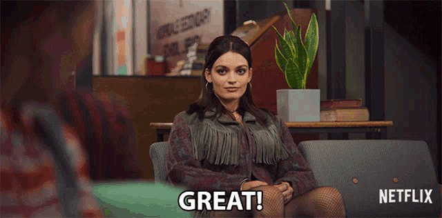 a woman sitting on a couch with the word great written on the screen