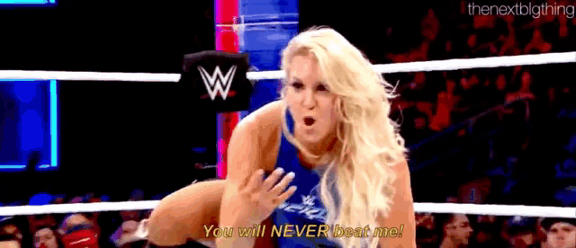 a woman is standing in a wrestling ring with a crowd watching .