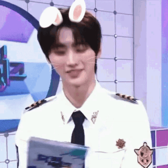 a man in a police uniform and tie is wearing a cat mask on his head .