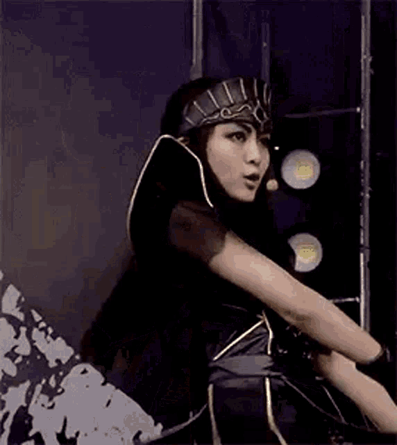 a woman in a costume is standing in front of a wall .
