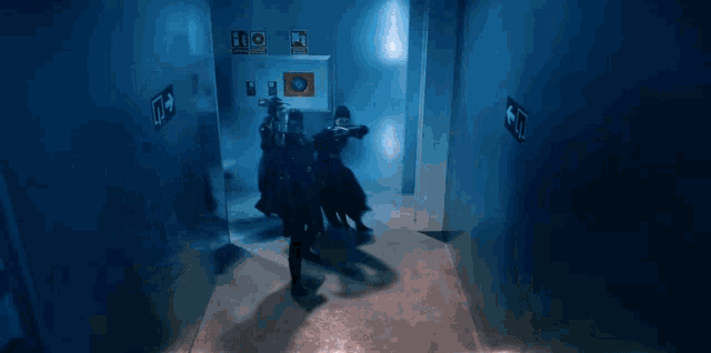 a blue hallway with a sign on the wall that says emergency exit