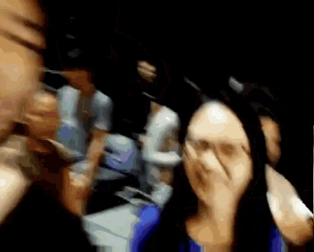 a blurry picture of a person 's face with a blue shirt on