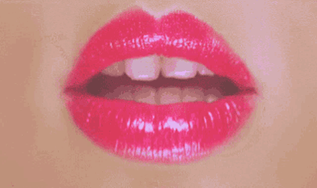 a close up of a woman 's mouth with red lipstick and white teeth