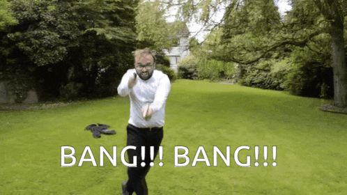 a man in a white shirt and black pants is standing in a grassy field with the words bang !!! bang !!! above him
