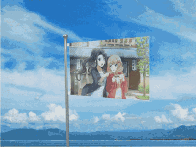 a flag flying in the wind with mountains in the background and a blue sky