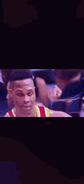 a close up of a basketball player 's face in a crowd of people .