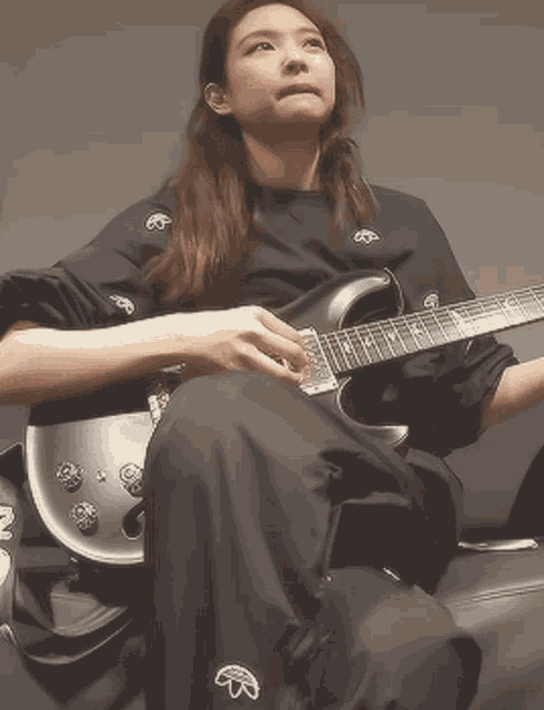 a woman sitting on a couch holding a guitar